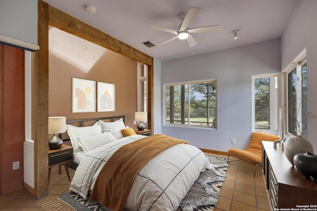 bedroom featuring light tile patterned floors, visible vents, beamed ceiling, and ceiling fan