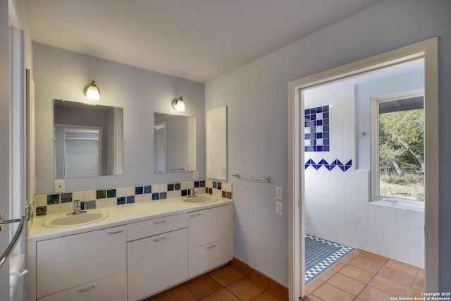 bathroom featuring tile patterned floors, double vanity, a tile shower, and a sink