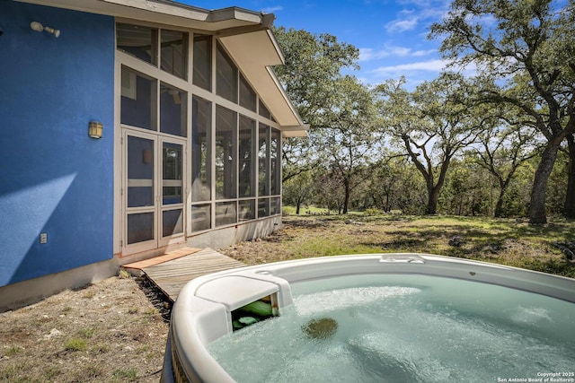 view of swimming pool with a hot tub and a sunroom