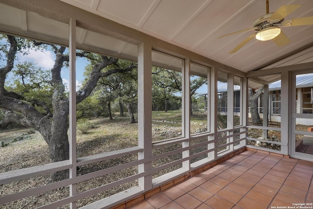 unfurnished sunroom with a ceiling fan and vaulted ceiling