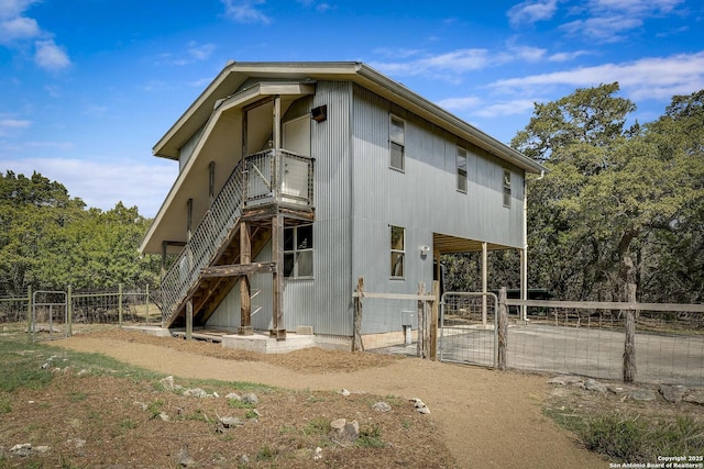 rear view of property with an outbuilding and a gate