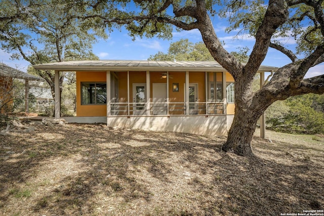 view of front of home with stucco siding and a sunroom