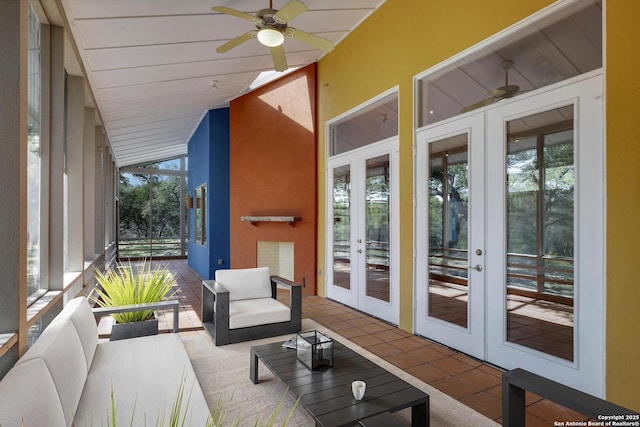 sunroom featuring a ceiling fan, vaulted ceiling, and french doors