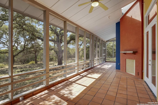 unfurnished sunroom with lofted ceiling and a ceiling fan