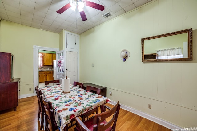 dining area featuring wood finished floors, a ceiling fan, visible vents, and baseboards