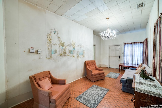 living area featuring a notable chandelier, visible vents, and baseboards