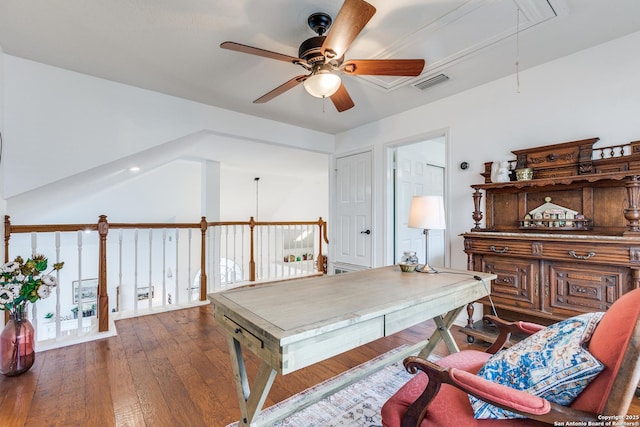 home office featuring visible vents, a ceiling fan, hardwood / wood-style flooring, attic access, and vaulted ceiling