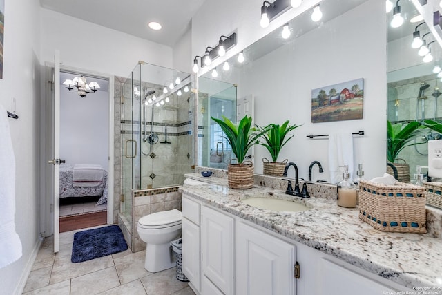 ensuite bathroom featuring vanity, a stall shower, ensuite bathroom, tile patterned floors, and toilet