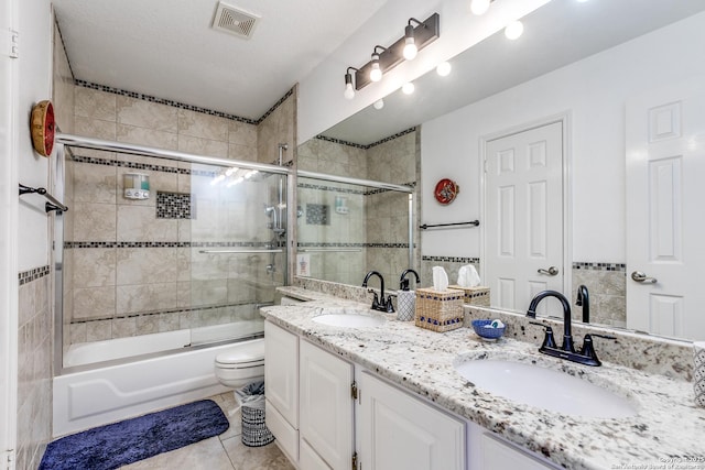 full bathroom with tile patterned flooring, visible vents, double vanity, and a sink