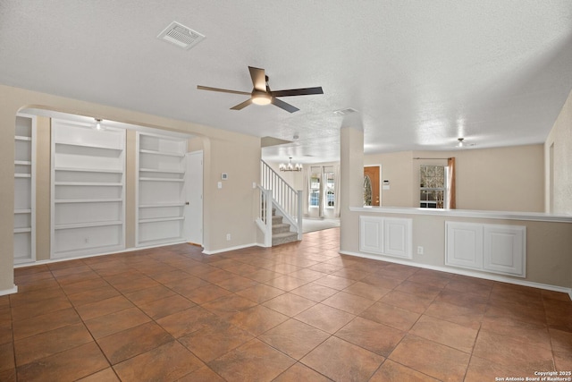 1967 Club Xing, New Braunfels, TX 78130 - unfurnished living room featuring built in features, a ceiling fan, visible vents, stairs, and a textured ceiling