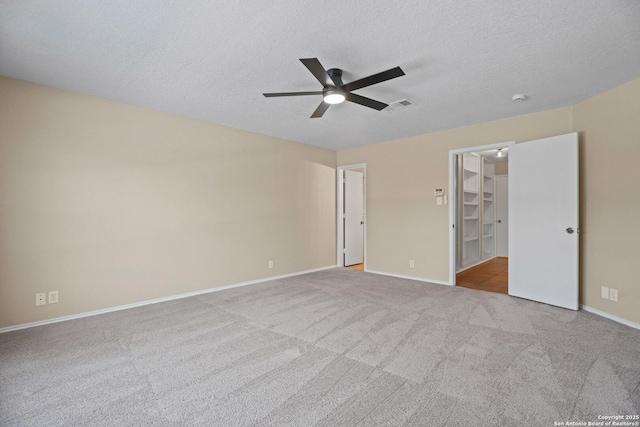1967 Club Xing, New Braunfels, TX 78130 - unfurnished bedroom with a walk in closet, carpet flooring, baseboards, and a textured ceiling