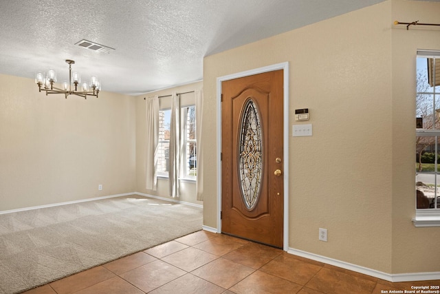 1967 Club Xing, New Braunfels, TX 78130 - foyer with visible vents, baseboards, a chandelier, light carpet, and a textured ceiling