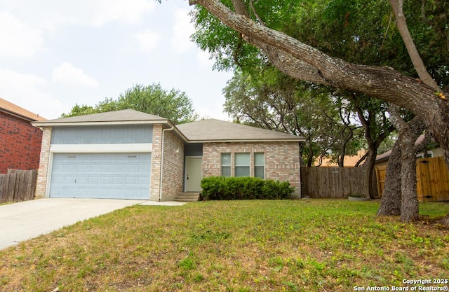 ranch-style home featuring a front yard, fence, driveway, an attached garage, and brick siding