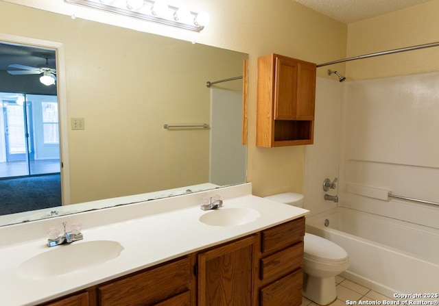 bathroom with a sink, toilet, tile patterned floors, and a textured ceiling