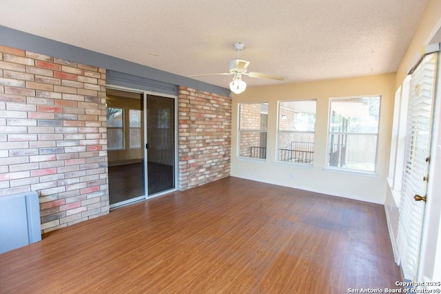 unfurnished sunroom featuring a ceiling fan