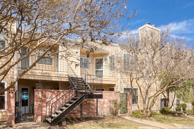 view of front facade featuring stairway and a chimney