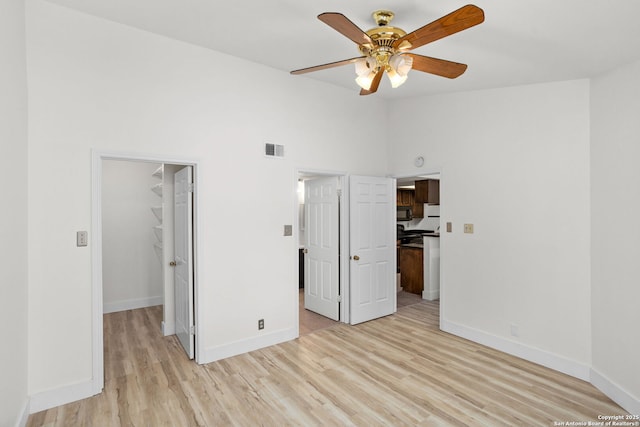 unfurnished bedroom featuring a walk in closet, visible vents, and a closet