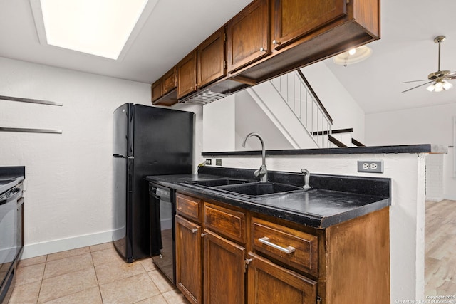 kitchen with black appliances, a ceiling fan, a sink, dark countertops, and baseboards