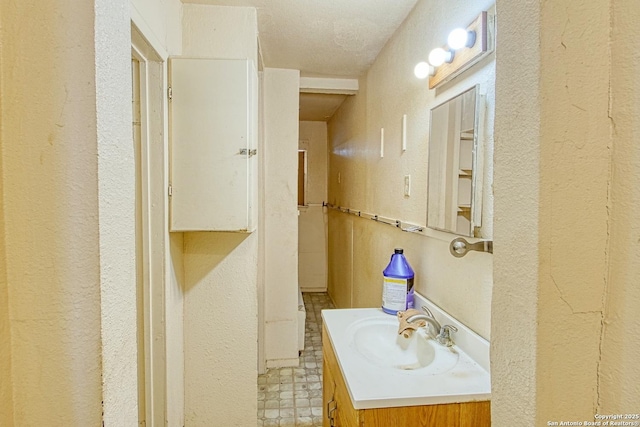 bathroom featuring vanity and a textured wall