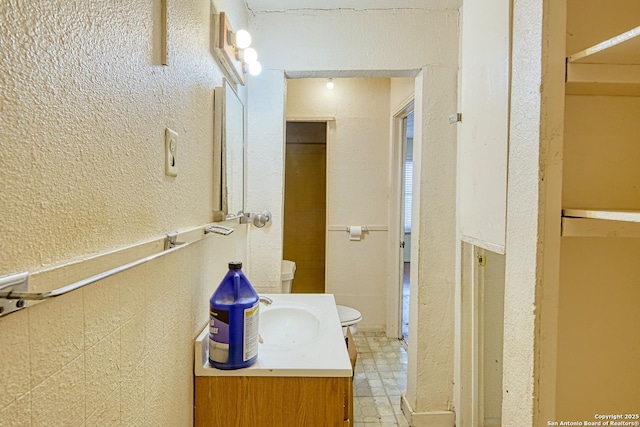 bathroom featuring vanity and a textured wall