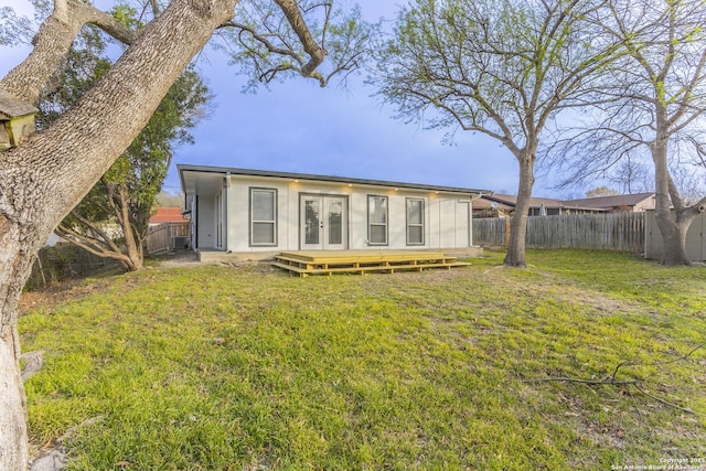 back of house with a lawn, french doors, and a fenced backyard