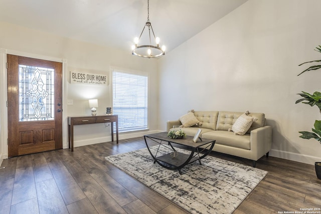 living room with an inviting chandelier, dark wood-type flooring, baseboards, and vaulted ceiling