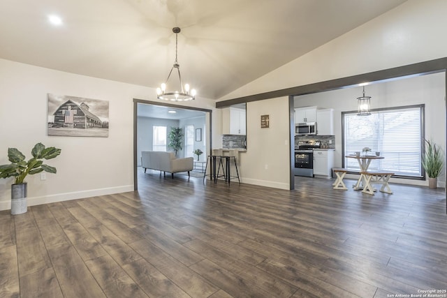 interior space featuring baseboards, lofted ceiling, a notable chandelier, and dark wood-type flooring