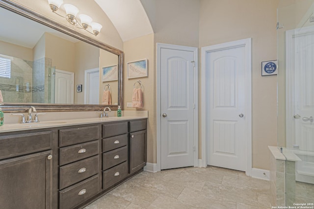 bathroom with double vanity, baseboards, a tile shower, and a sink