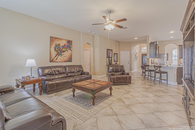 living room featuring arched walkways, recessed lighting, baseboards, and ceiling fan