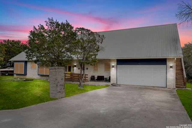 view of front of home featuring concrete driveway, a garage, stone siding, and metal roof