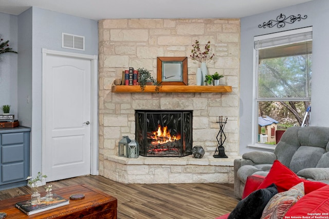 living room with visible vents, wood finished floors, and a fireplace