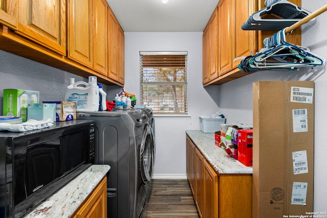 laundry area featuring washing machine and clothes dryer, cabinet space, dark wood finished floors, and baseboards