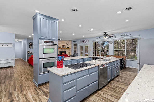 kitchen with visible vents, stainless steel appliances, a ceiling fan, and a sink