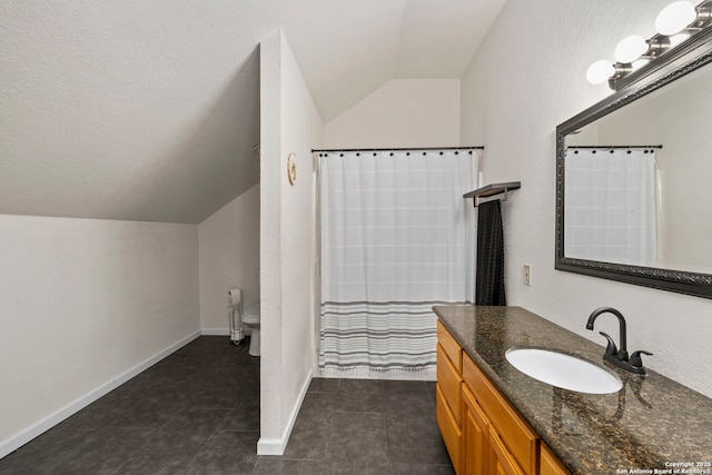 bathroom featuring toilet, vanity, baseboards, and vaulted ceiling