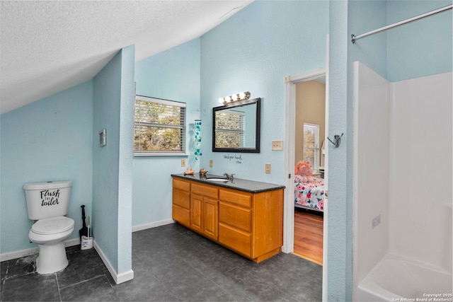 bathroom featuring vanity, baseboards, vaulted ceiling, a textured ceiling, and toilet