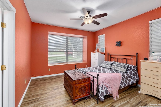 bedroom featuring a ceiling fan, baseboards, and wood finished floors