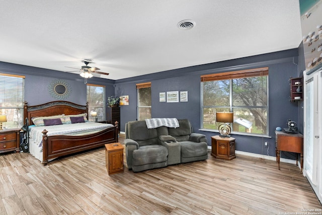 bedroom featuring a ceiling fan, light wood-style flooring, baseboards, and visible vents