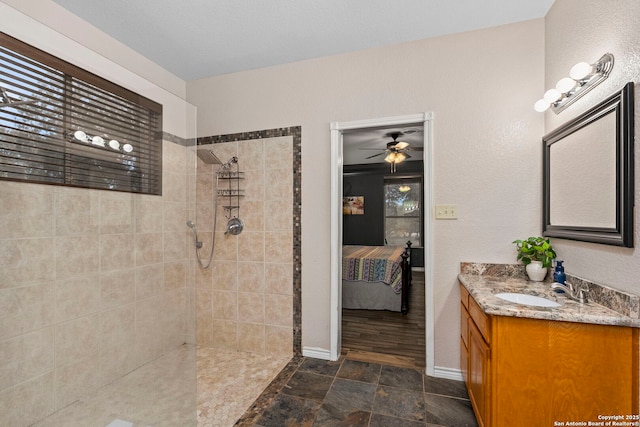 ensuite bathroom featuring ceiling fan, vanity, ensuite bathroom, and walk in shower