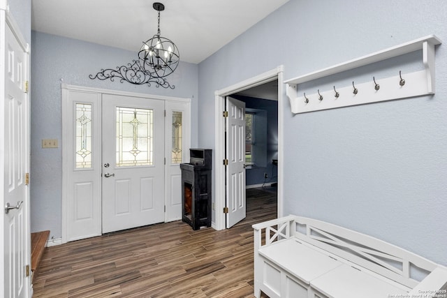 entryway with baseboards, dark wood-type flooring, and a chandelier