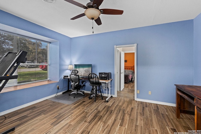 office space featuring a ceiling fan, wood finished floors, and baseboards