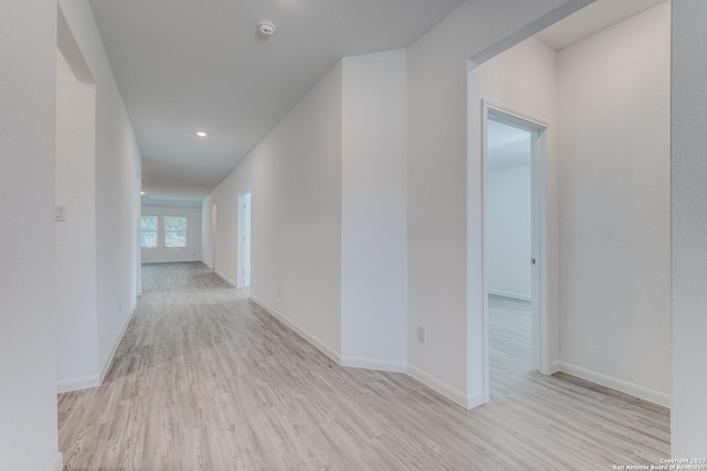 hallway featuring recessed lighting, wood finished floors, and baseboards