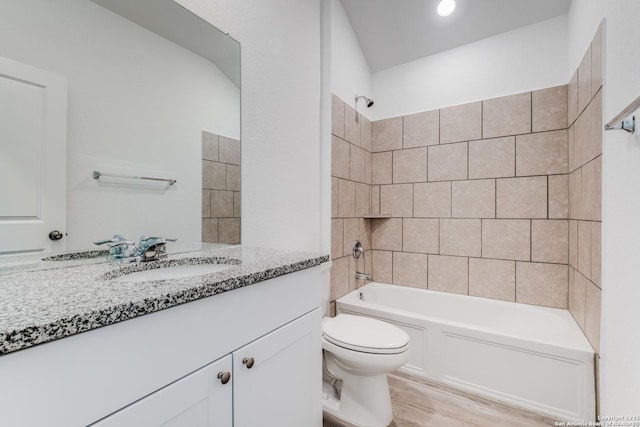 bathroom with shower / bathtub combination, toilet, wood finished floors, and vanity