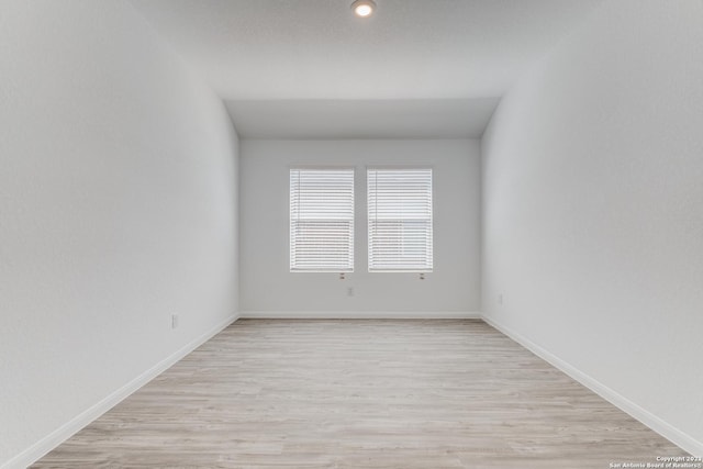 spare room featuring light wood finished floors and baseboards