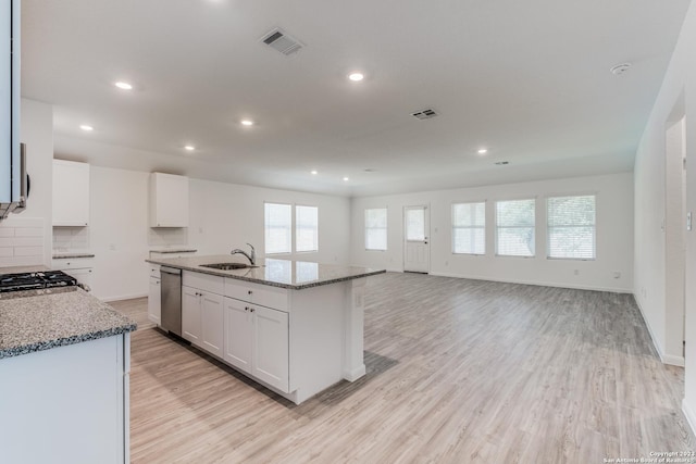 kitchen featuring visible vents, white cabinets, dishwasher, and light wood-style flooring