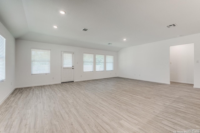 unfurnished living room with light wood-type flooring, visible vents, and plenty of natural light