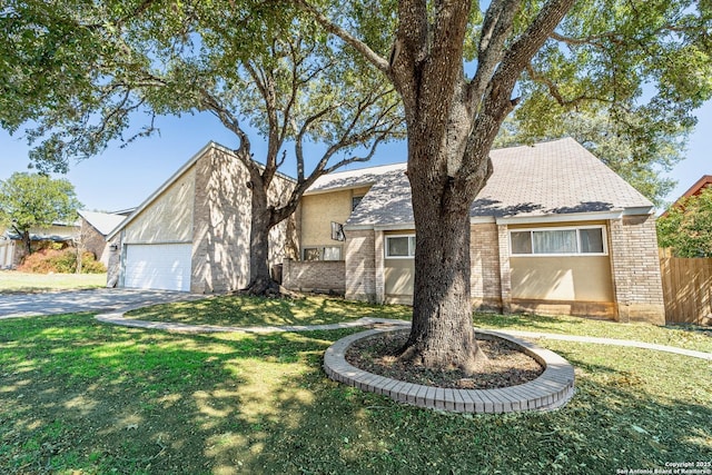 view of front facade with a garage, driveway, a front lawn, and fence