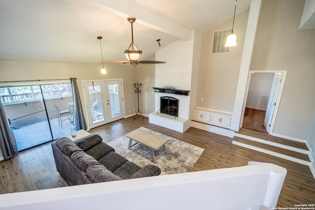 living area with visible vents, beam ceiling, high vaulted ceiling, and wood finished floors