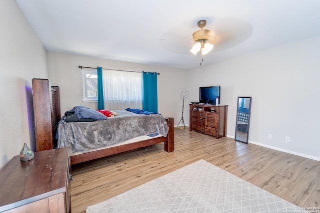 bedroom featuring wood finished floors, baseboards, and ceiling fan