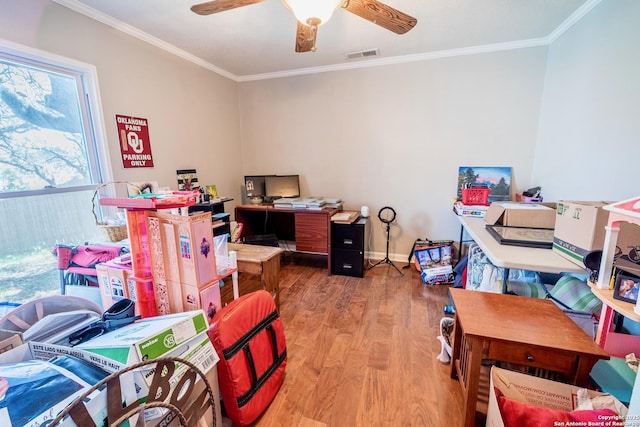 office space featuring visible vents, a ceiling fan, wood finished floors, and crown molding