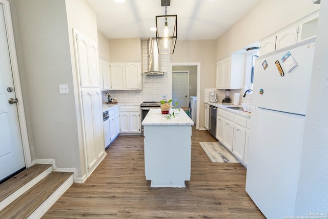 kitchen featuring a sink, light countertops, appliances with stainless steel finishes, white cabinetry, and a center island